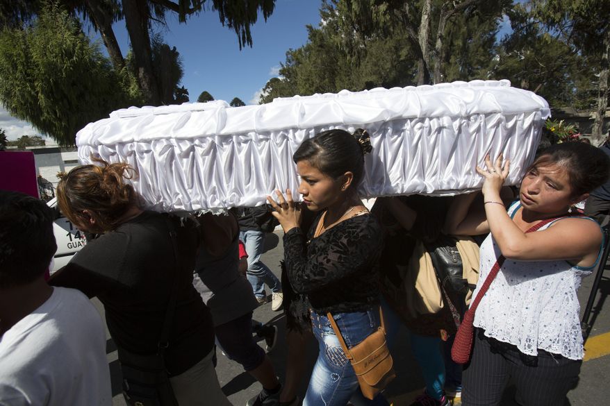FILE - In this March 10, 2017 file photo, women carry the coffin of 17-year-old Siona Hernandez Garcia, a girl who died in a March 8, 2016 fire at the Virgin of the Assumption Safe Home, at the cemetery in Guatemala City. On Tuesday, Feb. 19, 2019, a Guatemalan judge ordered five current and ex-officials to stand trial over the blaze that killed 41 girls and injured 15 others at the state-run home for troubled youth. (AP Photo/Moises Castillo, File)