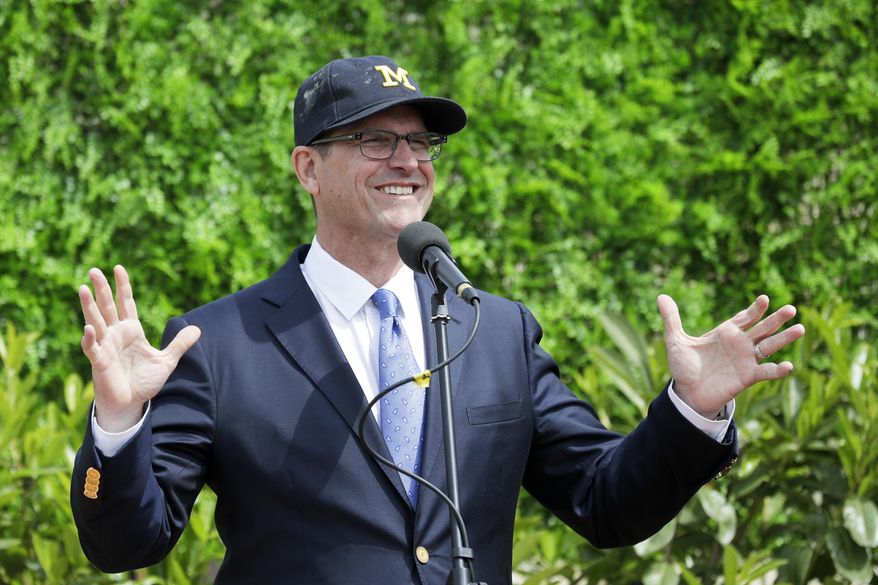 FILE - In this April 26, 2017, file photo, Michigan head football coach Jim Harbaugh talks to journalists during a press conference, in Rome. Harbaugh is taking Michigan’s football team to South Africa in May. Director of football operations Mark Taurisani tweeted about the trip Tuesday, Feb. 19, 2019. Like last year’s visit to France, the Wolverines will not practice in South Africa. Harbaugh did have practices in Italy in 2017. (AP Photo/Andrew Medichini, File)