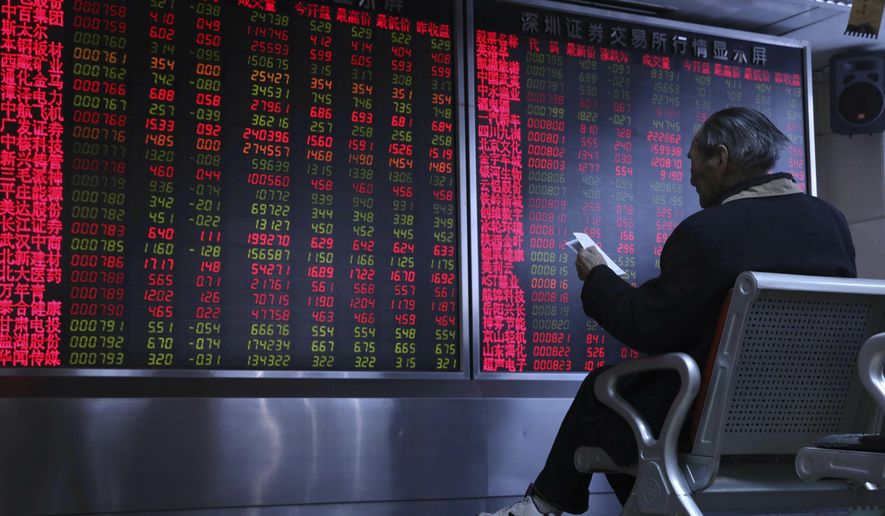 A Chinese man monitors stock prices at a brokerage in Beijing, China, Thursday, Feb. 21, 2019. Asian stock markets were little-changed Thursday following a listless day on Wall Street ahead of U.S.-Chinese negotiations aimed at ending a tariff battle. (AP Photo/Ng Han Guan)