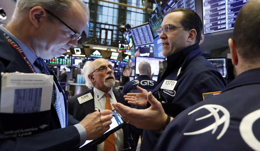 FILE- In this Feb. 15, 2019, file photo specialist Anthony Matesic, right, works with traders on the floor of the New York Stock Exchange. The U.S. stock market opens at 9:30 a.m. EST on Wednesday, Feb. 20. (AP Photo/Richard Drew, File)