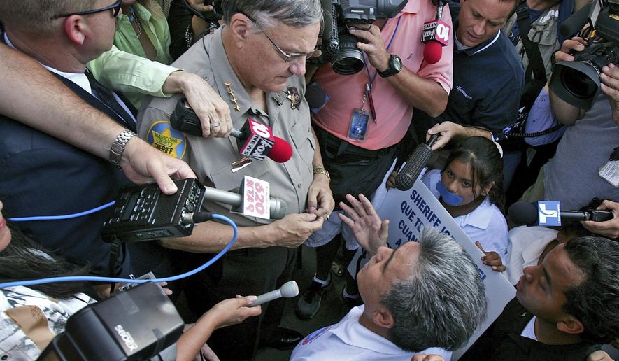 FILE - In this July 14, 2006, file photo, Elias Bermudez, lower right, kneels before then-Sheriff Joe Arpaio at a protest over the lawman&#x27;s immigration crackdowns. Bermudez, who led the pro-immigrant group Immigrants Without Borders, is scheduled to be sentenced Wednesday, Feb. 20, 2019, in Phoenix for a felony conviction stemming from his tax preparation business. (AP Photo/Matt York, File)