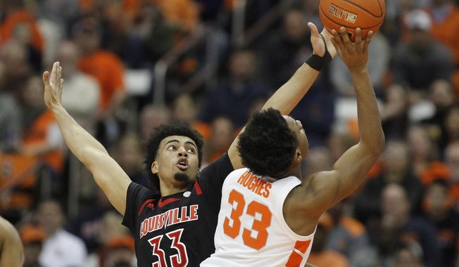 Louisville&#x27;s Jordan Nwora, left, defends Syracuse&#x27;s Elijah Hughes, right, during the first half of an NCAA college basketball game in Syracuse, N.Y., Wednesday, Feb. 20, 2019. (AP Photo/Nick Lisi)
