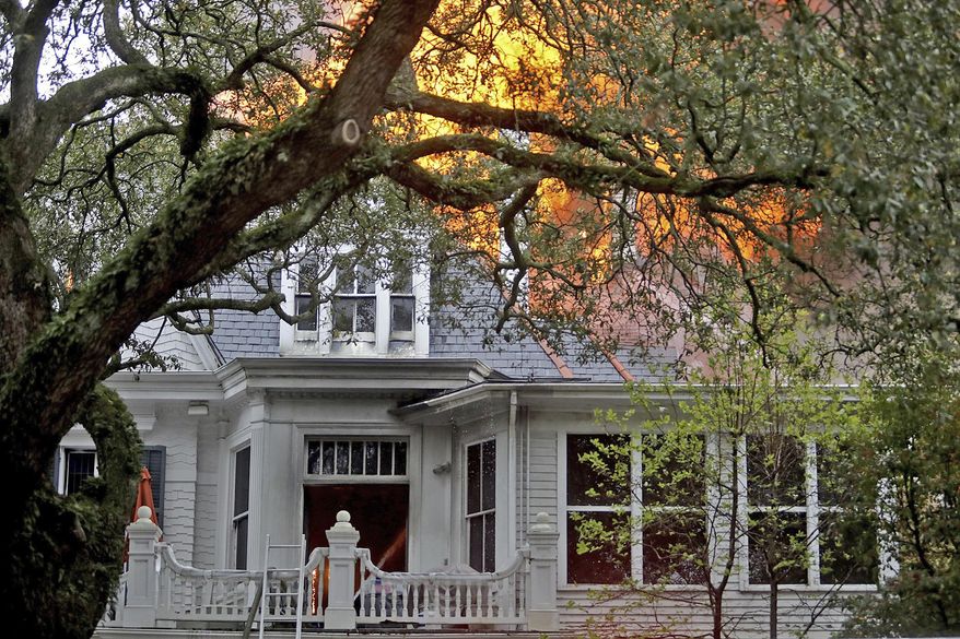 Flames break through the roof as the New Orleans Fire Department battles a seven-alarm fire the historic Morris-Downman House at 2525 St. Charles Avenue in New Orleans on Wednesday, February 20, 2019. (Michael DeMocker/The Times-Picayune via AP)