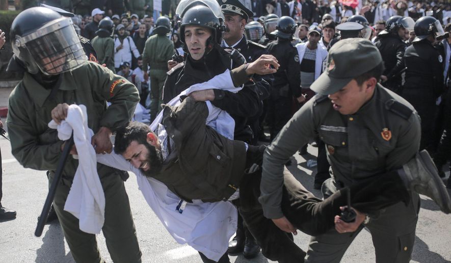 Security forces detain a protesting teacher during a demonstration in Rabat, Morocco, Wednesday, Feb. 20, 2019. Moroccan police fired water cannons at protesting teachers who were marching toward a royal palace and beat people with truncheons amid demonstrations around the capital Wednesday. (AP Photo/Mosa'ab Elshamy)