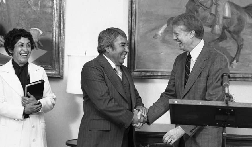 In this Nov. 30, 1978, file photo, President Jimmy Carter shakes hands with Dr. Armando Rodriguez of San Diego after he was sworn as a member of the Equal Employment Opportunity Commission at the White House in Washington. Rodriguez, a Mexican immigrant and World War II veteran went on served under four American presidents while pressing for civil rights, died Sunday, Feb. 17, 2019. He was 97. (AP Photo/Barry Thumma, File)