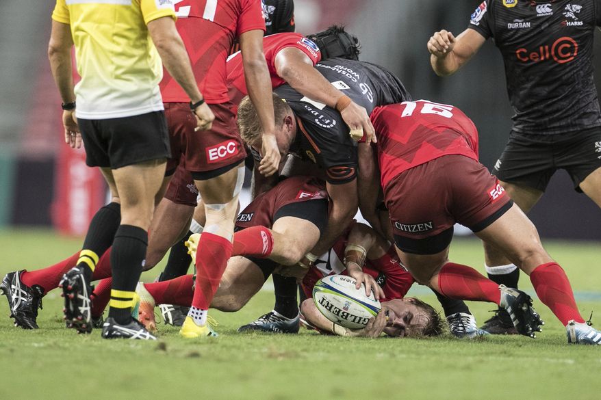 Hayden Parker of the Sunwolves gets tackled by Tyler Paul of the Sharks during the Super Rugby match between the Sunwolves and the Sharks at Singapore National Stadium, in Singapore, Saturday, Feb. 16, 2019. (AP Photo/Danial Hakim)