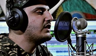 In this Tuesday, Feb. 12, 2019 photo, rapper Ahmed Chayeb, better known by his stage name Mr. Guti, records on his computer, at his home in the southern port city of Bqasra, Iraq. Chayeb raps about anger and disillusionment in his hometown of Basra, which saw riots last summer over failing services and soaring unemployment. Chayeb says his generation is fed up with the false piety of politicians and religious authorities who preach about faith and duty but have left Basra to fall apart. (AP Photo/Nabil al-Jurani)
