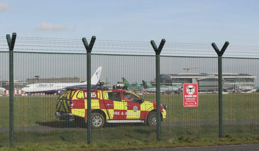 An emergency service vehicle by the perimeter fence after a confirmed drone sighting forced the temporary suspension of operations at Dublin Airport, Ireland, Thursday Feb. 21, 2019. Flights at Dublin Airport were grounded for a short time Thursday, to ensure the safety and security of passengers after a confirmed drone sighting. (Nial Carson/PA via AP)