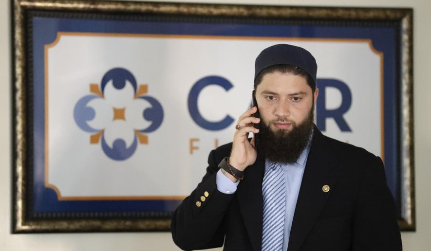 Hassan Shibly, attorney for Hoda Muthana, the Alabama woman who left home to join the Islamic State group in Syria, speaks on a phone before a news conference Wednesday, Feb. 20, 2019, in Tampa, Fla. United States Secretary of State Mike Pompeo said Muthana is not a U.S. citizen and will not be allowed to return to the United States. (AP Photo/Chris O&#x27;Meara)