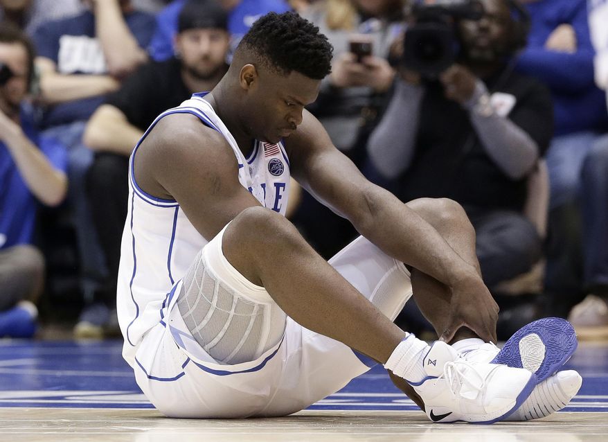Duke's Zion Williamson sits on the floor following a injury during the first half of an NCAA college basketball game against North Carolina, in Durham, N.C., Wednesday, Feb. 20, 2019. Duke might have to figure out what the Zion Show will look like without its namesake. All because of a freak injury to arguably the most exciting player in college basketball. As his Nike shoe blew out, Williamson sprained his right knee on the first possession of what became top-ranked Duke's 88-72 loss to No. 8 North Carolina.(AP Photo/Gerry Broome) **FILE**
