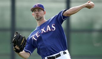 FILE - In this Feb. 15, 2019, file photo, Texas Rangers pitcher Mike Minor throws during spring training baseball practice in Surprise, Ariz. The Rangers were cautious with Minor last season in his Texas debut and his return to starting. He missed two years recovering from shoulder surgery and was a full-time reliever for Kansas City in 2017. Now the lefty is likely the Rangers&#39; opening day starter. (AP Photo/Charlie Riedel, File)