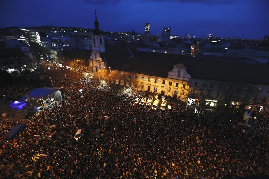 People gather on a square during a rally to mark one year anniversary of the slayings of an investigative reporter and his fiancee, in Bratislava, Slovakia, Thursday, Feb. 21, 2019. Jan Kuciak and Martina Kusnirova were shot dead in their home on Feb. 21 last year. People used the anniversary on Thursday to press for the investigation to be completed. (AP Photo/Petr David Josek)