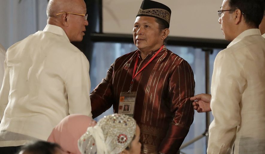 Abdullah Macapaar, center, who uses the nom de guerre Commander Bravo, talks with Defense Secretary Delfin Lorenzana, left, and Presidential Adviser on the Peace Process Carlito Galvez following oath-taking ceremony for the creation of the Bangsamoro Transition Authority or BTA at the Presidential Palace in Manila, Philippines Friday, Feb. 22, 2019. The Muslim rebels will serve as administrators of a new Muslim autonomous region in a delicate milestone to settle one of Asia&#x27;s longest-raging rebellions. Several commanders, including Commander Bravo, long wanted for deadly attacks were given safety passes to be able to travel to Manila and join the ceremony.(AP Photo/Bullit Marquez)