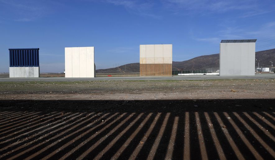 FILE - In this Wednesday, Dec. 12, 2018, file photo, border wall prototypes stand in San Diego near the Mexico-U.S. border, seen from Tijuana, Mexico, where the current wall casts a shadow in the foreground. Customs and Border Protection said Friday, Feb. 22, 2019, President Trump’s eight border-wall prototypes will be torn down to make way for a secondary barrier separating California from Mexico. (AP Photo/Moises Castillo, File)