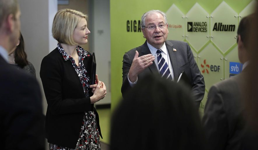 Massachusetts House Speaker Robert DeLeo, right, gestures prior to a tour at Greentown Labs in Somerville, Mass., Friday, Feb. 22, 2019. DeLeo has unveiled a plan to invest $1 billion over the next 10 years aimed at helping local cities and towns adopt new technologies designed to cut greenhouse gas emissions, strengthen infrastructure projects and reduce municipal costs. At left is Emily Reichert, CEO of Greentown Labs. (AP Photo/Charles Krupa)