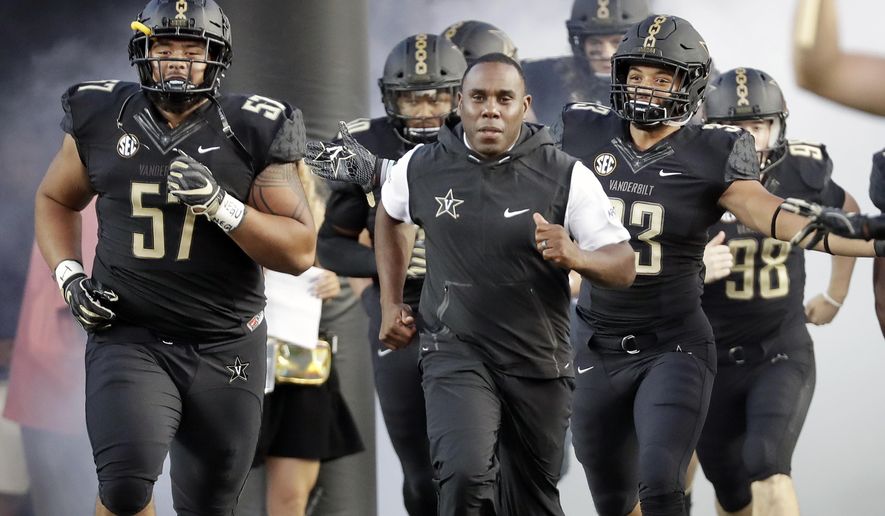 FILE - In this Sept. 1, 2018, file photo, Vanderbilt coach Derek Mason, center, runs onto the field with his team before its opening game of the NCAA college football season, against Middle Tennessee, in Nashville, Tenn. New Vanderbilt athletic director Malcolm Turner has extended the contract for coach Derek Mason after the Commodores reached a second bowl game in three seasons. Turner also announced Friday, Feb. 22, 2019, extensions for men’s golf coach Scott Limbaugh and bowling coach John Williamson.(AP Photo/Mark Humphrey, File)