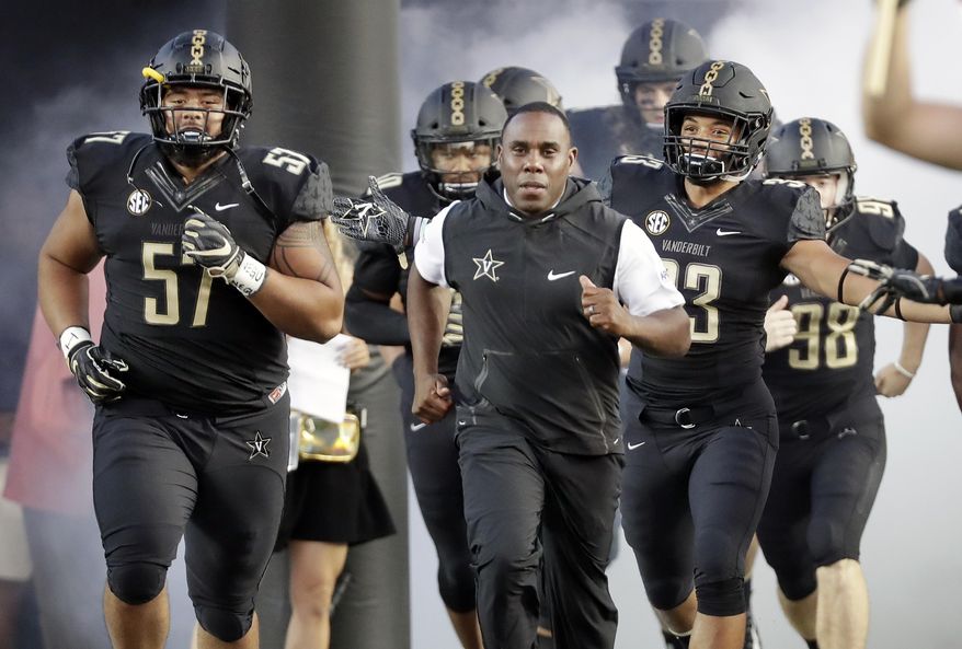 FILE - In this Sept. 1, 2018, file photo, Vanderbilt coach Derek Mason, center, runs onto the field with his team before its opening game of the NCAA college football season, against Middle Tennessee, in Nashville, Tenn. New Vanderbilt athletic director Malcolm Turner has extended the contract for coach Derek Mason after the Commodores reached a second bowl game in three seasons. Turner also announced Friday, Feb. 22, 2019, extensions for men’s golf coach Scott Limbaugh and bowling coach John Williamson.(AP Photo/Mark Humphrey, File)