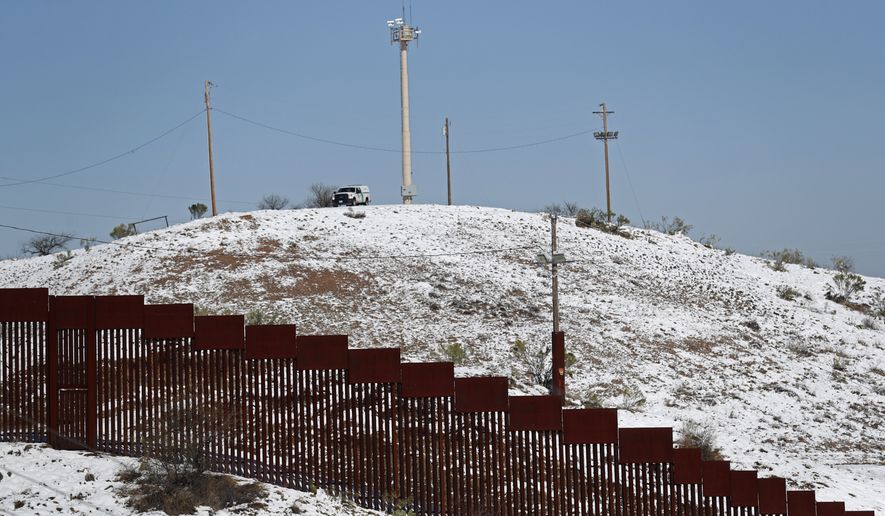 A US Border Patrol truck stands at the top of a snow capped hill overlooking the U.S. Mexico border wall in Nogales, Ariz., after a heavy snowfall, Saturday, Feb. 23, 2019, as seen from Nogales, Mexico. A winter storm dumped record-breaking amounts of snow in Arizona as well as in the northern Mexican city of Nogales. (AP Photo/Dario Lopez-Mills)