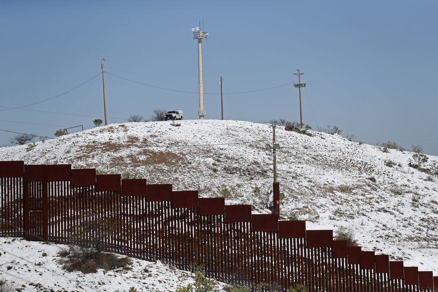 A US Border Patrol truck stands at the top of a snow capped hill overlooking the U.S. Mexico border wall in Nogales, Ariz., after a heavy snowfall, Saturday, Feb. 23, 2019, as seen from Nogales, Mexico. A winter storm dumped record-breaking amounts of snow in Arizona as well as in the northern Mexican city of Nogales. (AP Photo/Dario Lopez-Mills)