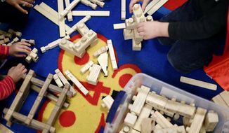 Kids play with wooden toys at the Hocking - Athens - Perry Head Start, in Logan, Tuesday, Feb. 12, 2019. The group of nine retired woodworkers get together once a week to make toys for Head Start programs all across the state. (Courtney Hergesheimer/The Columbus Dispatch via AP)