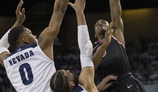 Fresno State guard New Williams (0) shoots over the arms of Nevada forward Tre&#39;Shawn Thurman (0) and forward Cody Martin (11) in the first half of an NCAA college basketball game in Reno, Nev., Saturday, Feb. 23, 2019. (AP Photo/Tom R. Smedes)