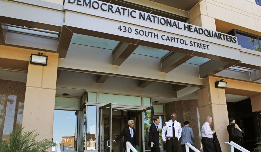 In this June 14, 2016, file photo, people stand outside the Democratic National Committee headquarters in Washington. Hackers tried to break into DNC inboxes in March 2016 and intensified their efforts in early April. (AP Photo/Paul Holston, File)