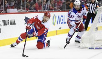 Washington Capitals center Evgeny Kuznetsov (92), of Russia, reaches for the puck against New York Rangers center Mika Zibanejad (93) during the first period of an NHL hockey game, Sunday, Feb. 24, 2019, in Washington. (AP Photo/Nick Wass) ** FILE **