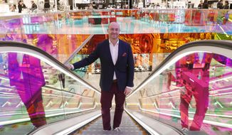 In this Wednesday, Feb. 20, 2019, photo Saks Fifth Avenue President Marc Metrick rides the escalator inside the company&#39;s flagship midtown Manhattan store, in New York. A company insider, the 45-year-old Metrick aims to reinvent the department store experience to bring theater to luxury shopping at a time when shoppers can buy their designer handbags online. (AP Photo/Kathy Willens)