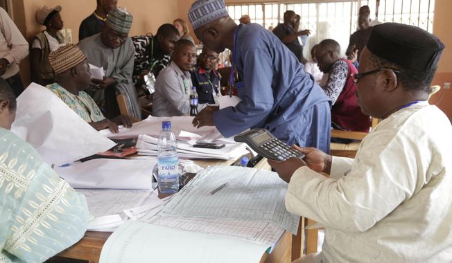 Electoral officials compile voting results at a collation center in Yola, n Nigeria, Sunday, Feb. 24, 2019. Vote counting continued Sunday as Nigerians awaited the outcome of a presidential poll seen as a tight race between the president and a former vice president. (AP Photo/Sunday Alamba)