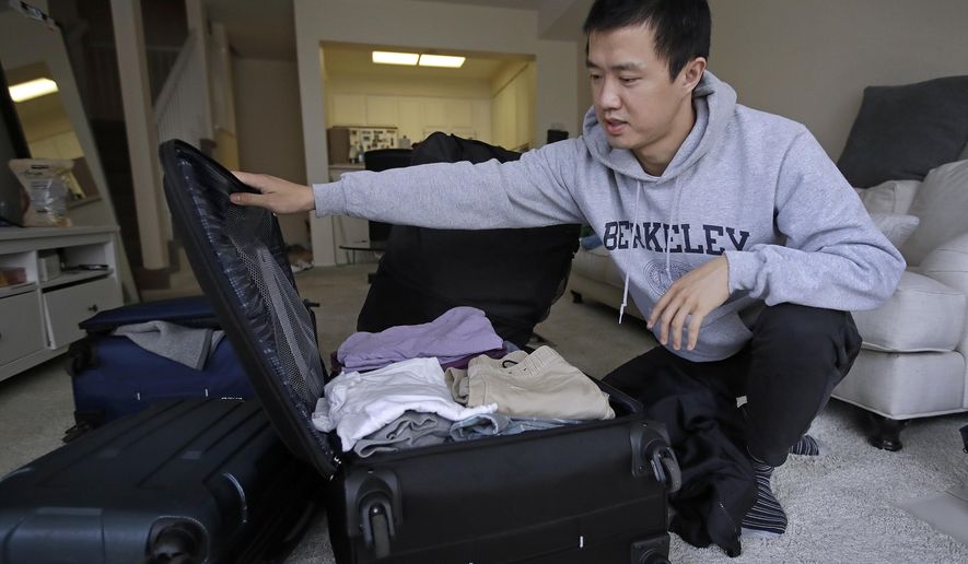 In this Monday, Feb. 4, 2019, photo, Leo Wang packs a suitcase at his home in San Jose, Calif. Wang has found himself trapped in an obstacle course regarding H-1B work visas for foreigners. His visa denied and his days in the United States numbered, Wang is looking for work outside the country. “I still believe in the American dream,” he says. “It’s just that I personally have to pursue it somewhere else.” (AP Photo/Ben Margot)