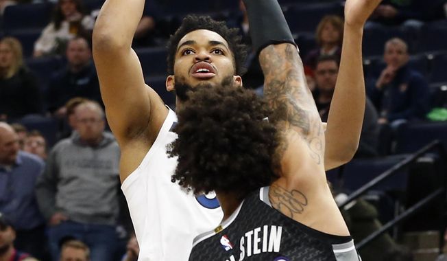 Minnesota Timberwolves&#x27; Karl-Anthony Towns, left, shoots over Sacramento Kings&#x27; Willie Cauley-Stein in the first half of an NBA basketball game Monday, Feb. 25, 2019, in Minneapolis. (AP Photo/Jim Mone)
