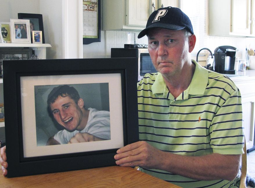In this Feb. 14, 2019, photo, Dean Palozej poses with a photo of his son, Spencer, in Stafford, Conn. Spencer Palozej died of a fentanyl overdose in last year. His father supports a proposed state law that would create a new murder charge for people who supply drugs that cause fatal overdoses. The opioid crisis has spurred many state and federal officials to consider more serious charges for overdose deaths. (AP Photo/Dave Collins)