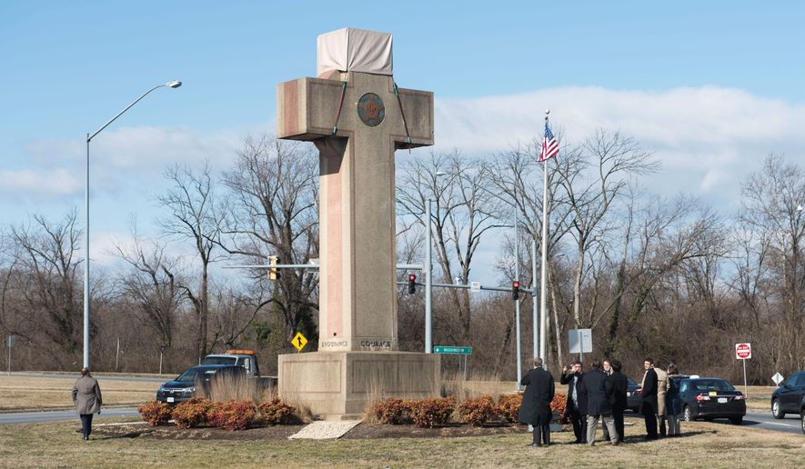 Visitors walk around the 40-foot Maryland Peace Cross dedicated to World War I soldiers on Wednesday, Feb. 13, 2019 in Bladensburg, Md. (AP Photo/Kevin Wolf)