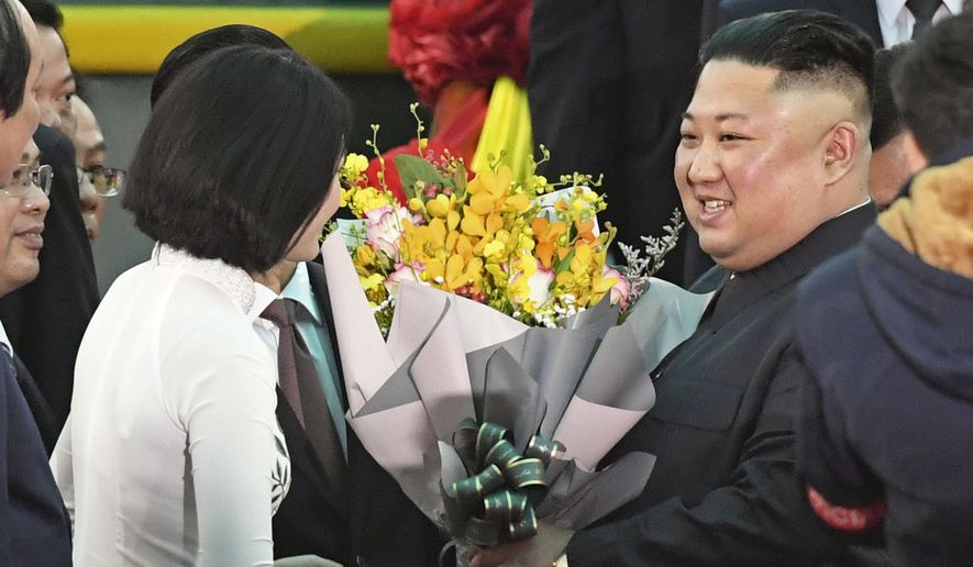 North Korean leader Kim Jong Un, right, receives bouquets on his arrival at the Dong Dang railway station in Dong Dang, a Vietnamese border town Tuesday, Feb. 26, 2019, ahead of his second summit with U.S. President Donald Trump. (Minoru Iwasaki/Kyodo News via AP)