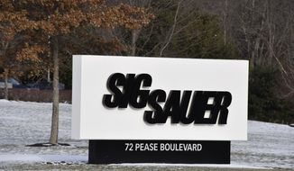 This Thursday, Jan. 14, 2016, file photo shows the sign at the entrance to the headquarters of Sig Sauer, a gun manufacturer based in Newington, N.H. Three former executives of German gun-maker Sig Sauer have gone on trial in Germany on suspicion of illegally selling firearms to Colombia by funneling them through a U.S. sister company. (AP Photo/Lisa Marie Pane, file)