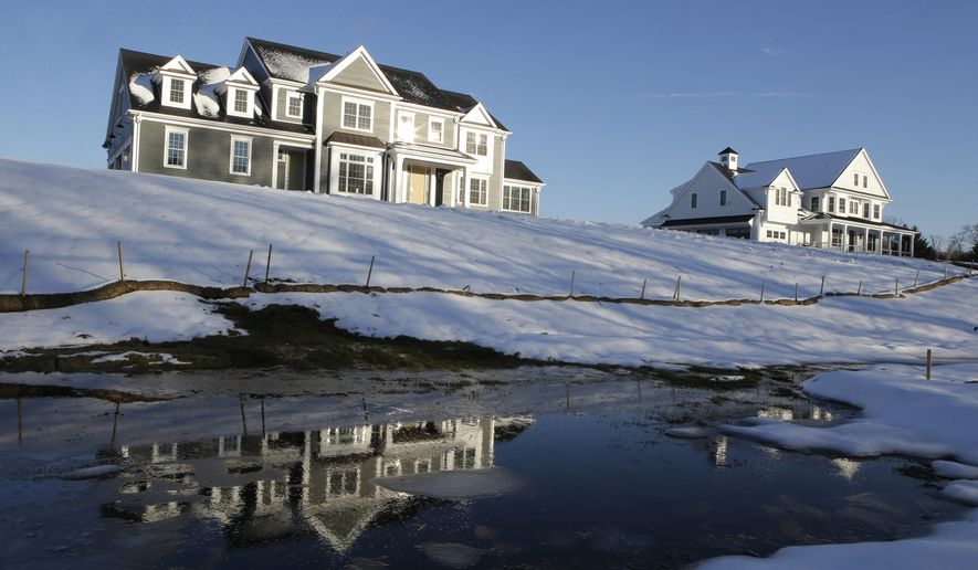In this Thursday, Feb. 21, 2019 photo a recently constructed home, left, is reflected in water, in Natick, Mass. On Tuesday, Feb. 26, the Commerce Department reports on U.S. home construction in December. (AP Photo/Steven Senne)