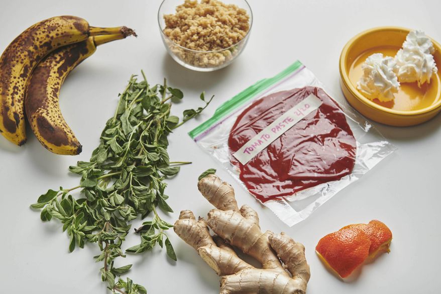 This February 2019 photo taken in New York shows a variety of foods that are surprisingly freezable. From left are bananas, fresh oregano, cooked quinoa in glass bowl, ginger, tomato paste, orange peel and whipped cream mounds. (Cheyenne M. Cohen/Katie Workman via AP)