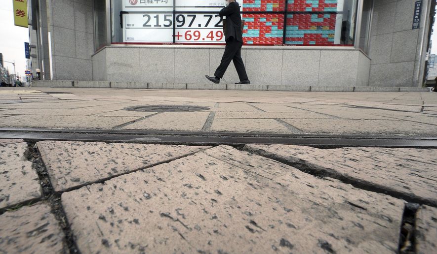 A man walks past an electronic stock board showing Japan's Nikkei 225 index at a securities firm in Tokyo Tuesday, Feb. 26, 2019. Most Asian share benchmarks are lower as a rally spurred by the Trump administration's decision to hold off on increasing tariffs on imported Chinese goods fades. (AP Photo/Eugene Hoshiko)