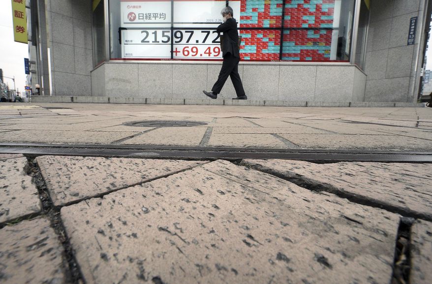 A man walks past an electronic stock board showing Japan's Nikkei 225 index at a securities firm in Tokyo Tuesday, Feb. 26, 2019. Most Asian share benchmarks are lower as a rally spurred by the Trump administration's decision to hold off on increasing tariffs on imported Chinese goods fades. (AP Photo/Eugene Hoshiko)