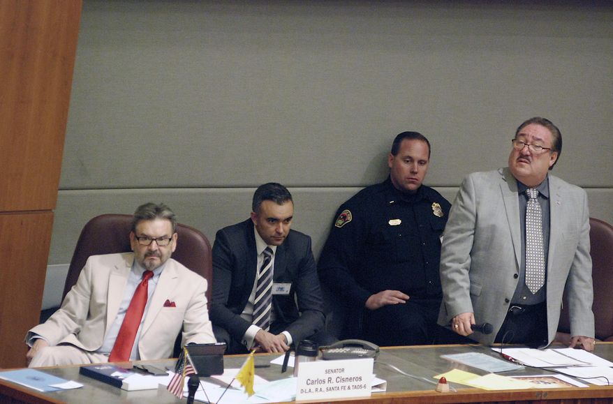 Democratic state Sen. Richard Martinez, right, of Espanola, stands for questions about a bill he sponsors that would expand background checks to nearly all private gun sales in New Mexico, Thursday, Feb. 14, 2019, in Santa Fe, N.M. The bill passed to clear its last major hurdle. (AP Photo/Morgan Lee)