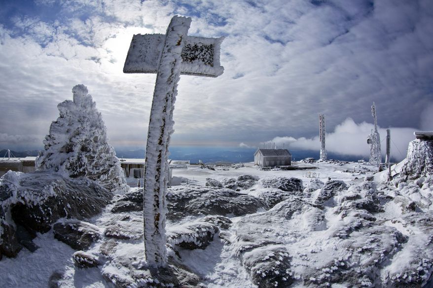FILE - In this March 10, 2015 file photo, a sign marks the snow-caked summit of the 6,288-foot Mount Washington in New Hampshire. Meteorologists said a wind gust on Monday, Feb. 25, 2019, atop the mountain hit 171 mph, setting a record for the month which beat the previous February wind record of 166 mph set in 1972. It also was the strongest wind recorded there in any month since 1985. (AP Photo/Robert F. Bukaty, File)