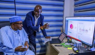 In this photo released by the Nigeria State House, Nigeria Incumbent President Muhammadu Buhari, left, listen to Director of Election Planning and Monitoring Babatunde Raji Fashola, right, as he explain the progress of the party election results in Abuja, Nigeria Monday, Feb. 25, 2019. Nigeria&#39;s electoral commission on Monday began announcing official results from the country&#39;s 36 states as President Muhammadu Buhari seeks a second term. (Bayo Omoboriowo/Nigeria State House via AP)