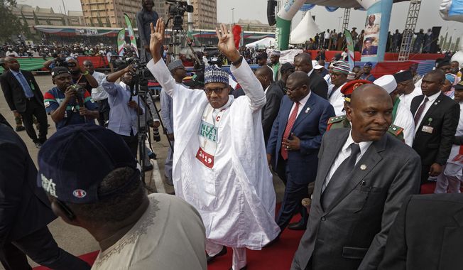 FILE - In this Wednesday, Feb. 13, 2019 file photo, incumbent President Muhammadu Buhari gestures to supporters at a campaign rally in Abuja, Nigeria. Nigeria&#x27;s president was poised to win a second term in Africa&#x27;s largest democracy, with unofficial results on Tuesday, Feb. 26, 2019 showing a victory, his campaign spokesman said. (AP Photo/Ben Curtis, File)