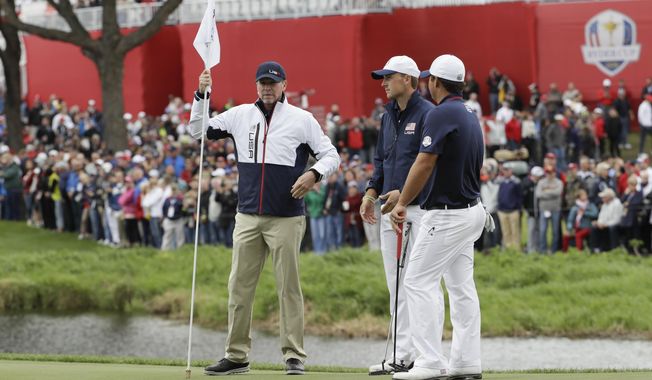 File-This Sept. 28, 2016, file photo shows United States vice-captain Steve Stricker, left, holding a flag for United States’ Jordan Spieth and United States’ Patrick Reed during a practice round for the Ryder Cup golf tournament at Hazeltine National Golf Club in Chaska, Minn. Stricker called Reed before he was named Ryder Cup captain to clear the air. (AP Photo/David J. Phillip, File)