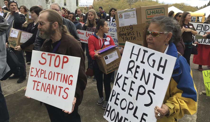 FILE - In this April 12, 2017, file photo, supporters of a bill to ban most no-cause evictions of home renters in Oregon demonstrate on the Capitol steps in Salem, Ore. Oregon is set to become the first state in the nation to impose mandatory rent control. The measure sailed through the Democratically-controlled House on Tuesday, Feb. 26, 2019. Landlords would only be allowed to raise rent a limited amount once per year under the bill, which previously passed the Senate. (AP Photo/Andrew Selsky, File)