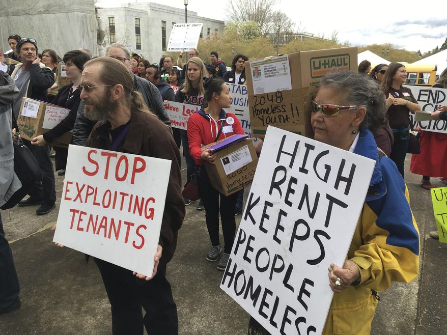 FILE - In this April 12, 2017, file photo, supporters of a bill to ban most no-cause evictions of home renters in Oregon demonstrate on the Capitol steps in Salem, Ore. Oregon is set to become the first state in the nation to impose mandatory rent control. The measure sailed through the Democratically-controlled House on Tuesday, Feb. 26, 2019. Landlords would only be allowed to raise rent a limited amount once per year under the bill, which previously passed the Senate. (AP Photo/Andrew Selsky, File)