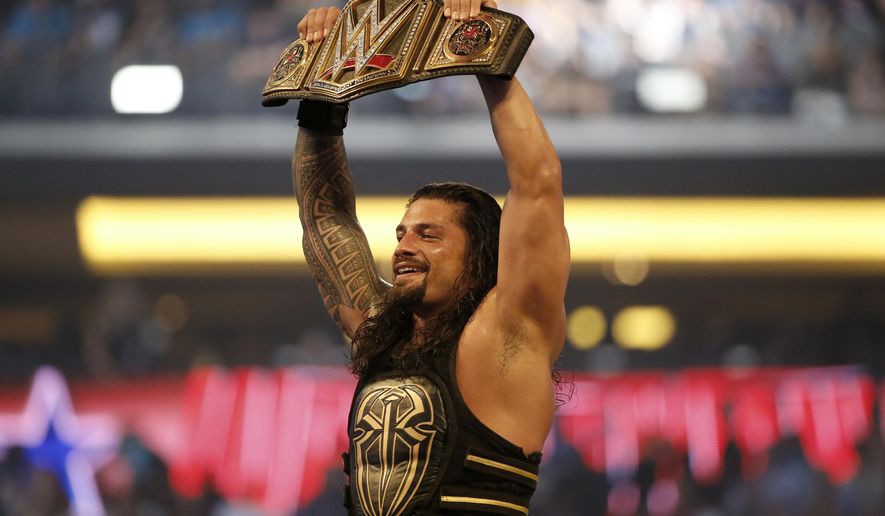 FILE - In this April 3, 2016 file photo, Roman Reigns holds up the championship belt after defeating Triple H during WrestleMania 32 at AT&T Stadium in Arlington, Texas. Reigns says his leukemia is in remission and he’ll be returning to the WWE ring. The 33-year-old, whose real name is Leati Joseph Anoai, made the announcement Monday, Feb. 25, 2019 at a WWE Raw event in Atlanta. (Jae S. Lee/The Dallas Morning News via AP)