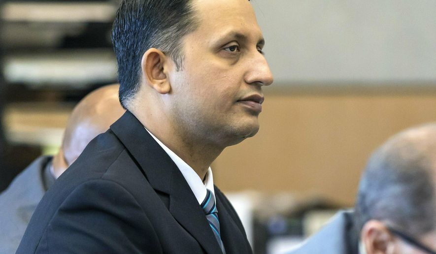 Former Palm Beach Gardens police officer Nouman Raja listens to defense attorney Scott Richardson give opening statements in Raja's trial, Tuesday, Feb. 26, 2019, in West Palm Beach, Fla. Raja is charged with the fatal 2015 shooting of a stranded black motorist, 31-year-old Corey Jones. (Lannis Waters/Palm Beach Post via AP, Pool)