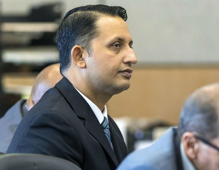 Former Palm Beach Gardens police officer Nouman Raja listens to defense attorney Scott Richardson give opening statements in Raja's trial, Tuesday, Feb. 26, 2019, in West Palm Beach, Fla. Raja is charged with the fatal 2015 shooting of a stranded black motorist, 31-year-old Corey Jones. (Lannis Waters/Palm Beach Post via AP, Pool)