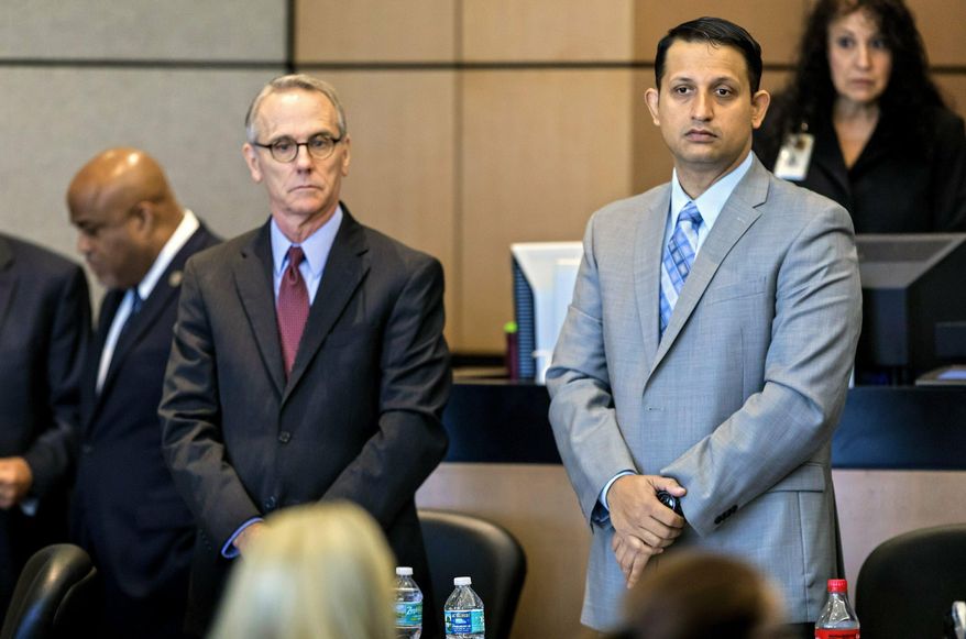 Defense attorney Scott Richardson and Nouman Raja, right, watch as prospective jurors for his trial enter the courtroom Monday, Feb. 25, 2019 in West Palm Beach, Fla. Raja, a former Palm Beach Gardens police officer, is charged with shooting and killing stranded motorist Corey Jones on Oct. 18, 2015. He is charged with manslaughter by culpable negligence while armed and attempted first-degree murder with a firearm. (Lannis Waters/Palm Beach Post via AP, Pool)